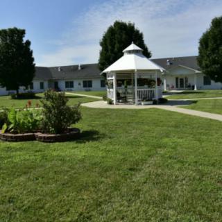 A well-maintained garden with a white gazebo and lush green lawn.