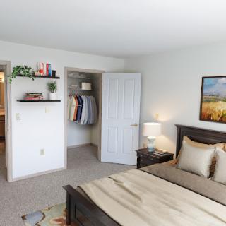 A cozy and well-decorated bedroom featuring a wooden bed frame, bedside lamp, and organized closet.