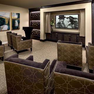 A luxurious home theater with comfortable seating and a large screen.