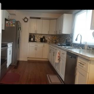 A modern kitchen featuring sleek white cabinets, stainless steel appliances, and a spacious layout.