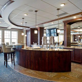A modern bar and restaurant with elegant interior design featuring wooden counters and ample seating.