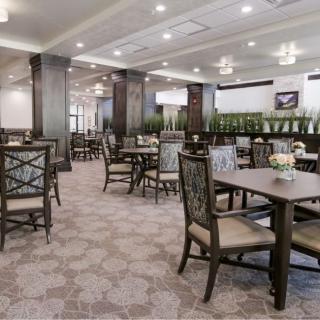 A spacious and elegantly designed restaurant dining area with neatly arranged tables and chairs.