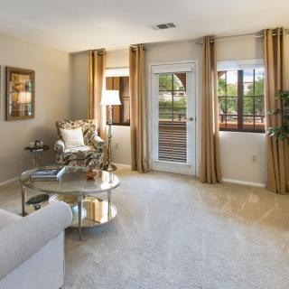 A cozy living room with elegant furniture and large windows letting in natural light.
