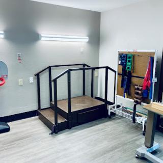 A physical therapy space equipped with a ramp for rehabilitation exercises.