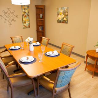 A neatly arranged dining room with a wooden table set for a meal.