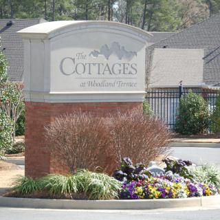 Entrance sign for Cottages at Ridge Point, surrounded by landscaping and flowers.
