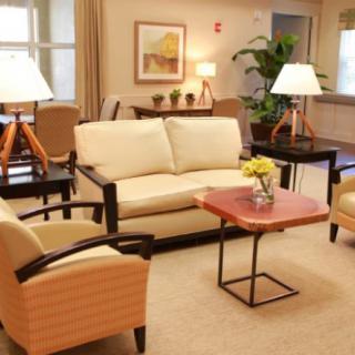 A cozy living room with a sofa, chairs, coffee table, and warm lighting.