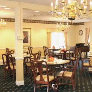 A well-decorated dining room with elegant chandeliers and neatly arranged tables and chairs.