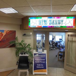 Entrance to a fitness center with a bright sign and welcoming decor.