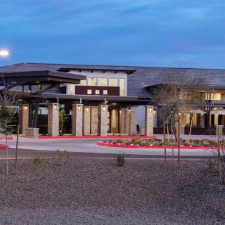A modern building with a well-designed entrance, set against an evening sky.