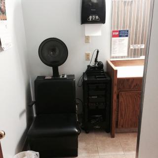 A compact hair salon setup with a salon chair and hair dryer.