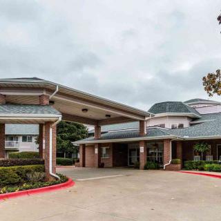 A building with a covered entrance and a driveway in front.