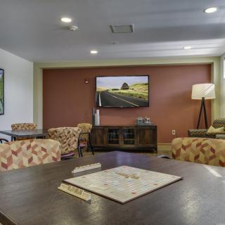 A cozy living room with comfortable seating and a television on the wall.