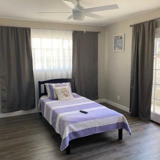 A minimalist bedroom with a single bed and gray curtains.