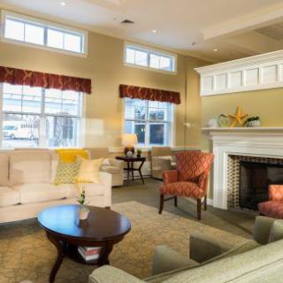 A cozy living room with sofas, armchairs, and a fireplace.