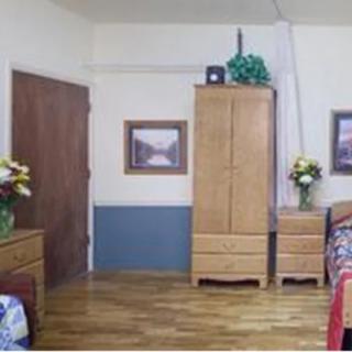 A cozy bedroom with wooden furniture and floral decorations.