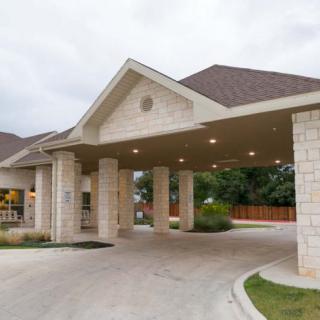 A building entrance with covered driveway and columns.