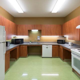 A modern kitchen featuring wooden cabinets and essential appliances.