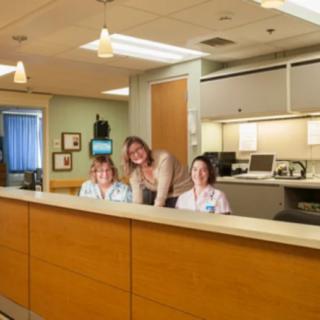Reception area with smiling healthcare staff at a hospital.
