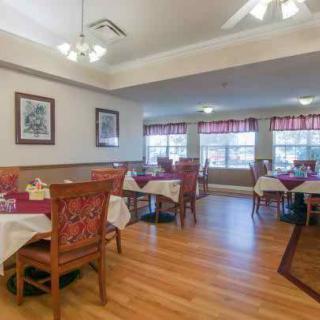 A cozy dining area with elegantly set tables and warm lighting.