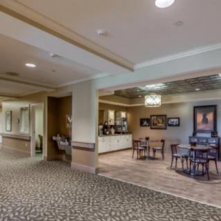 A cozy lobby area with a carpeted floor, seating arrangement, and a coffee station.