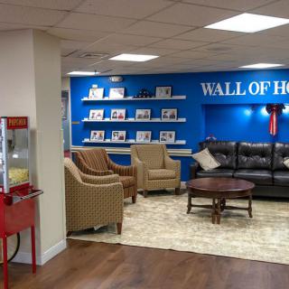A cozy lounge area with comfortable seating and a 'Wall of Heroes' display.