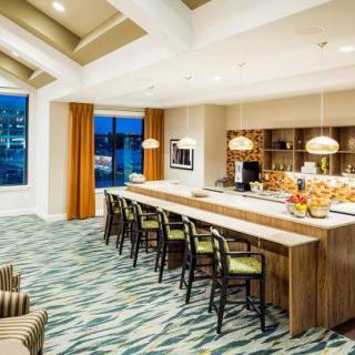 A modern kitchen and dining area with bar stools and stylish lighting.