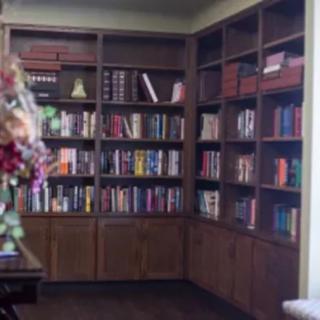 A cozy corner with wooden bookshelves filled with a variety of books.