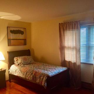 Cozy bedroom with single bed and warm lighting.