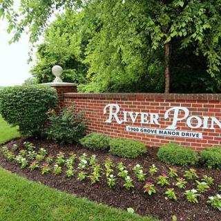 Entrance to River Pointe community with landscaped flowers and greenery.