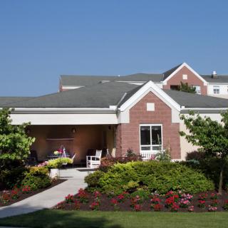 A well-maintained residential building with a lush garden and neat landscaping.