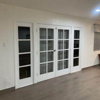 A modern living room featuring white-framed glass doors.