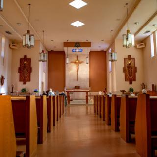 A serene interior view of a church, showcasing the altar and wooden pews.
