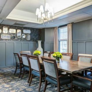 Elegant dining room with a large table, chairs, and decorative lighting.