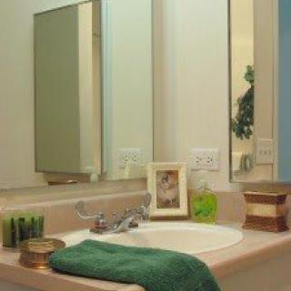 A neatly arranged bathroom sink area with a mirror and decorative items.