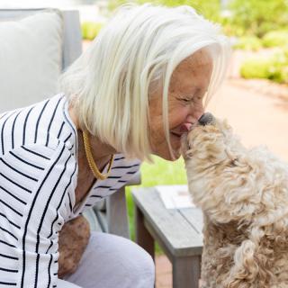 A woman shares a joyful moment with her dog in the park.