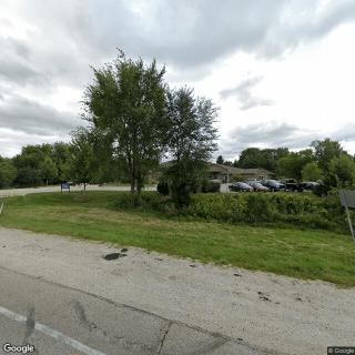 A suburban street with trees and a cloudy sky.