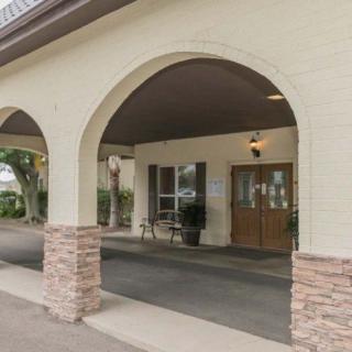 An exterior view of a building with an arched entrance and double doors.