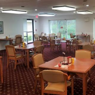 A spacious dining area featuring several tables and chairs, designed for comfortable seating and dining.