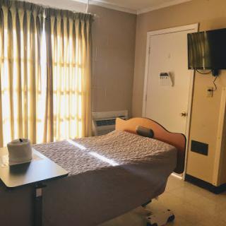 A serene hospital room with natural light filtering through yellow curtains.