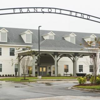 A large building with a prominent entrance and an arched sign overhead.