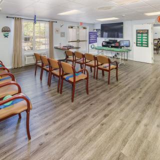 A modern waiting area with neatly arranged chairs and a television on the wall.