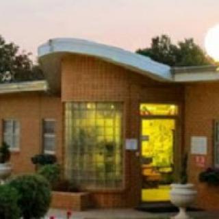 A modern building with a unique design illuminated by the warm glow of sunset.