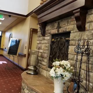 A welcoming lobby featuring a beautifully crafted stone fireplace and tasteful floral arrangements.
