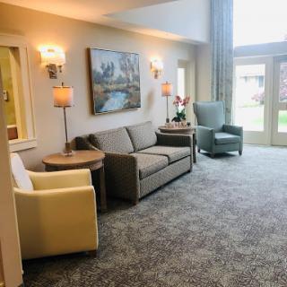 A cozy living room setting with comfortable furniture, soft lighting, and a view of the outdoors.