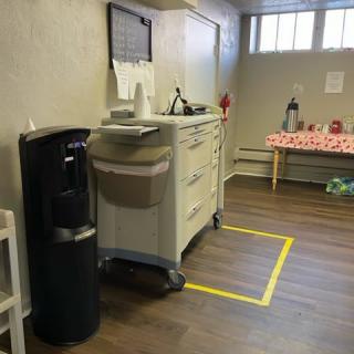 An office break area with a water cooler, cart, and coffee station.