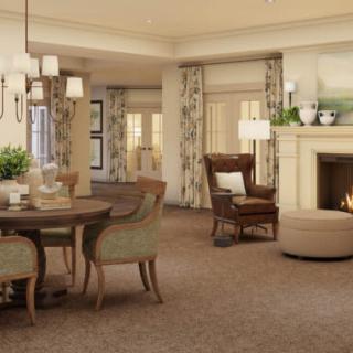 A cozy and elegantly designed living room featuring a fireplace, dining table, and classic furniture.