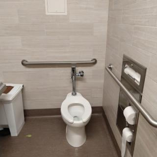 An accessible restroom equipped with handrails and a modern toilet.