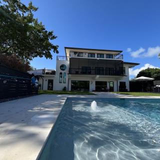 A modern luxury house with a swimming pool on a sunny day.
