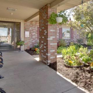 A welcoming building entrance with a landscaped garden and pathway.